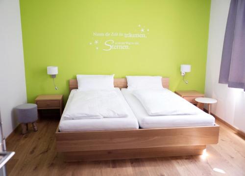 Cama en habitación con pared verde en Gleiseins, en Naila