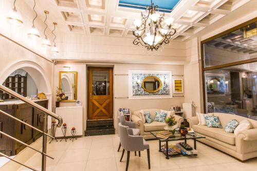 a living room with two couches and a chandelier at Paradise Hotel in Parga