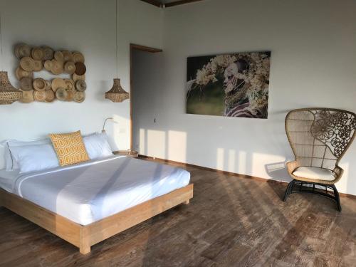 a bedroom with a bed and a chair in it at Balian Prana in Selemadeg