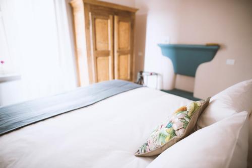 a white bed with a pillow on top of it at Moonfrà in Antignano