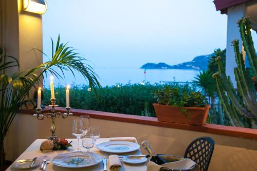 a table with candles and a view of the ocean at Park Hotel Silemi in Letojanni