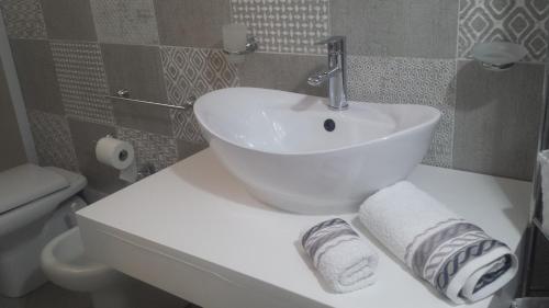 La salle de bains est pourvue d'un lavabo blanc et de toilettes. dans l'établissement Villa Cecilia, à Montallegro