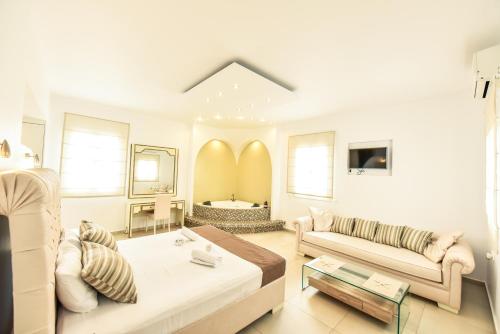 a living room with a bed and a couch at Queen Boutique Suites in Mikonos