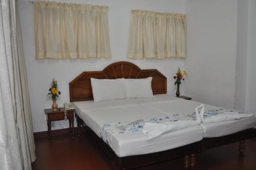 a bed with a wooden headboard in a bedroom at Marine Palace Beach Hotel in Kovalam