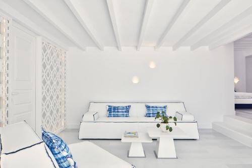 a white living room with a couch and a table at Katikies Mykonos - The Leading Hotels of the World in Agios Ioannis Mykonos