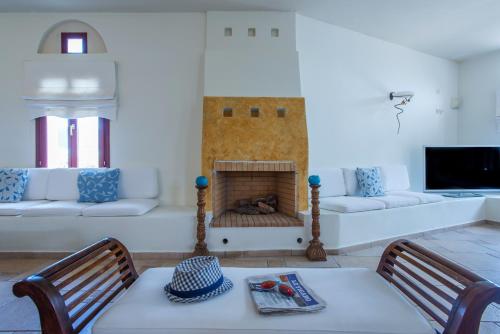 a living room with a fireplace with a table and chairs at Naxos Palace Hotel in Stelida