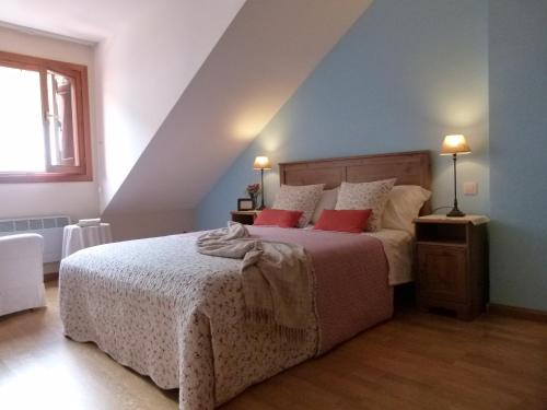 a bedroom with a bed with two red pillows at Apartamento Broto in Broto