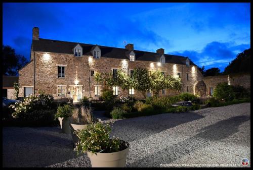 a large brick building with lights on it at Demeures & Châteaux, La Ferme des Mares in Saint-Germain-sur-Ay
