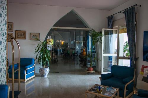 a living room with blue chairs and a table at Park Hotel Silemi in Letojanni