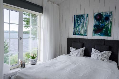 ein Schlafzimmer mit einem großen weißen Bett und einem Fenster in der Unterkunft Haus Kilstrand in Tämta
