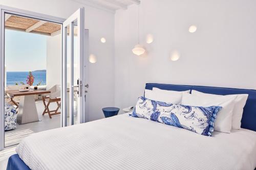 a bedroom with a bed and a view of the ocean at Katikies Mykonos - The Leading Hotels of the World in Agios Ioannis Mykonos