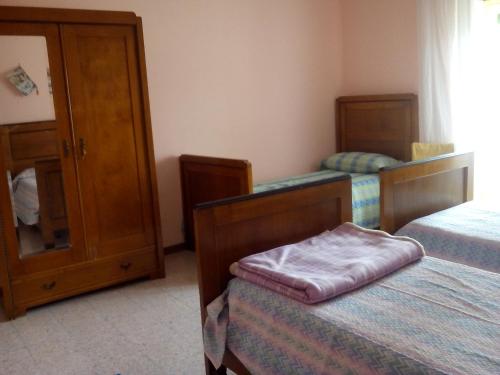 1 Schlafzimmer mit 2 Betten und einem Schrank in der Unterkunft La grotta di nonno Vittorio in San Pio delle Camere