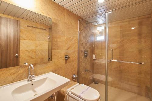 ein Bad mit einem WC, einem Waschbecken und einer Dusche in der Unterkunft Hotel The Evergrand Palace in Rajkot