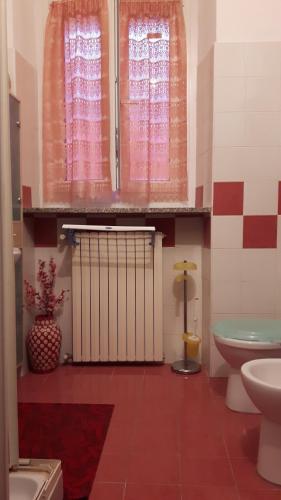 a bathroom with a toilet and a sink and a window at Appartamento "Da Mamma Agnese" in Gorgonzola