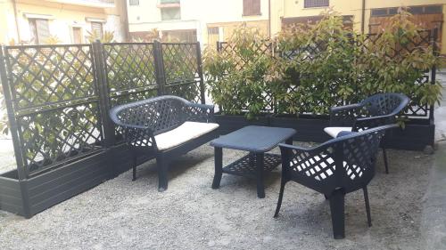 three chairs and a bench next to a fence at Appartamento "Da Mamma Agnese" in Gorgonzola
