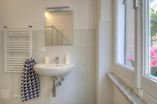 a bathroom with a sink and a mirror and a window at Rione San Carlo in Finale Ligure