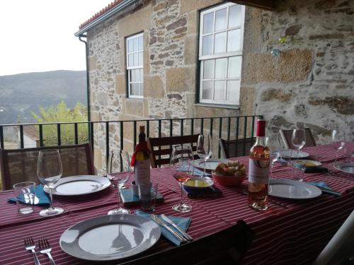 a table with plates and wine bottles and glasses on it at Mesao Provesende in Provesende