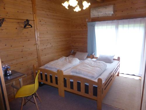 Schlafzimmer mit einem Bett, einem Schreibtisch und einem Stuhl in der Unterkunft Pension Blue Drop in Yakushima