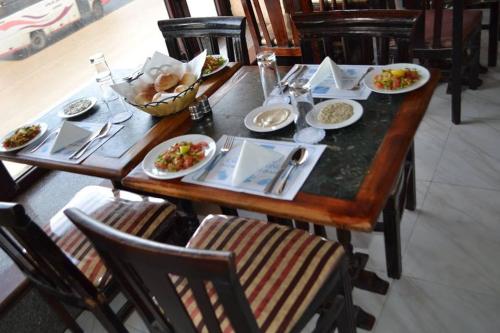 a wooden table with plates of food on it at Kaoud Sporting Hotel in Alexandria
