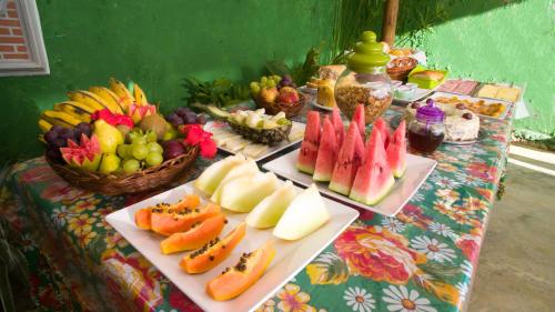 a table with two plates of fruit on it at Pousada Bicho Preguiça in Itacaré