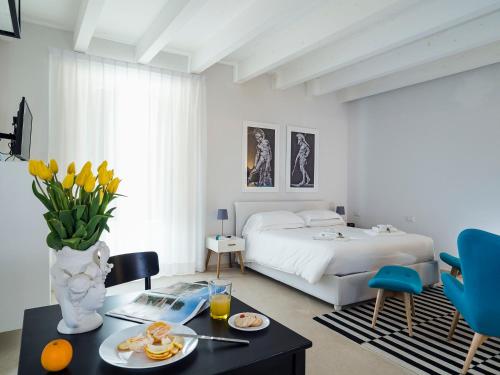 Un dormitorio con una cama y una mesa con comida. en Re Federico Boutique Hotel en Siracusa