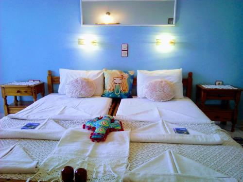 two beds in a bedroom with white sheets at Paradisso Studios in Vromolithos
