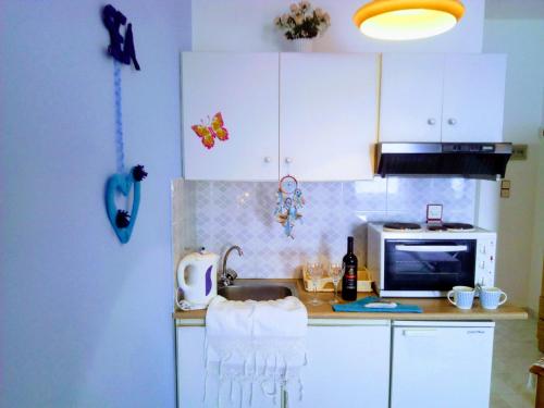 a kitchen with a sink and a microwave at Paradisso Studios in Vromolithos