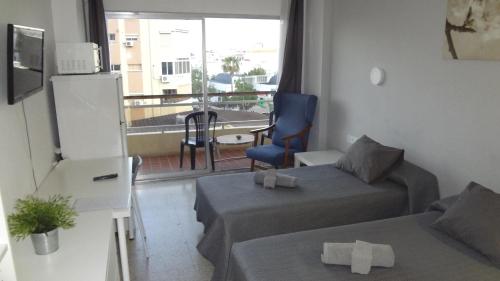 a small room with two beds and a balcony at Hotel Carlos I in Torremolinos