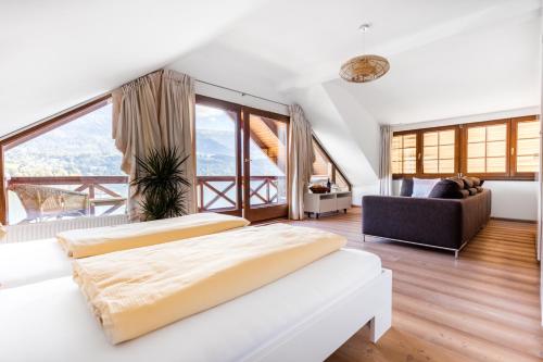 two beds in a room with large windows at Seevilla Leitner in Seeboden