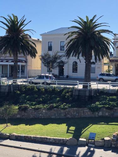 a park with palm trees in front of a building at Albany Foreshore Guest House in Albany