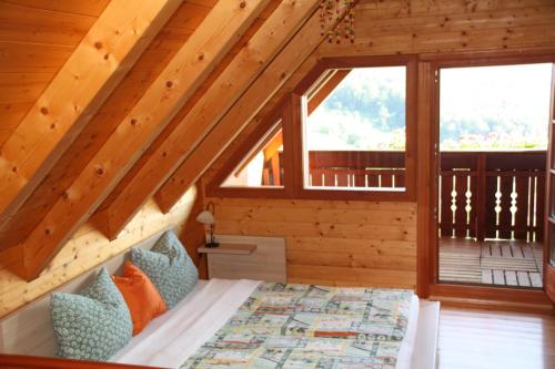 ein Schlafzimmer mit einem Bett in einer Holzhütte in der Unterkunft Kellerstöckl am Rosenberg in Straden