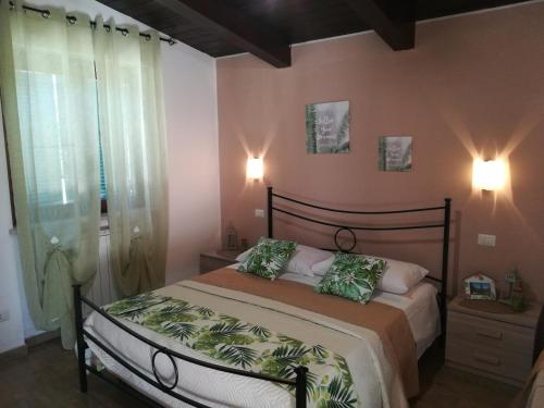 a bedroom with a bed with two green pillows at Agriturismo Santa Maria in Marta