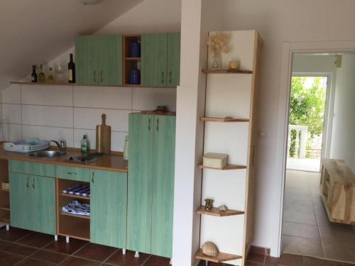 a kitchen with green cabinets and a sink at Apartments Sofija in Tivat