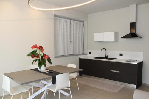 a kitchen with a table and a sink and a vase of flowers at Hotel Il Grappolo D'Oro in Monforte dʼAlba