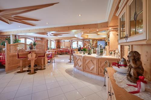 a large kitchen with wooden cabinets and a dining room at Alpenhotel Schönwald Superior in Valles