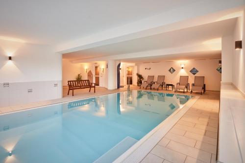 a large swimming pool with blue water in a hotel at Alpenhotel Schönwald Superior in Valles