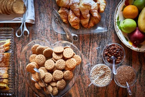 a table with a bunch of pastries and other foods at Alpenhotel Schönwald Superior in Valles