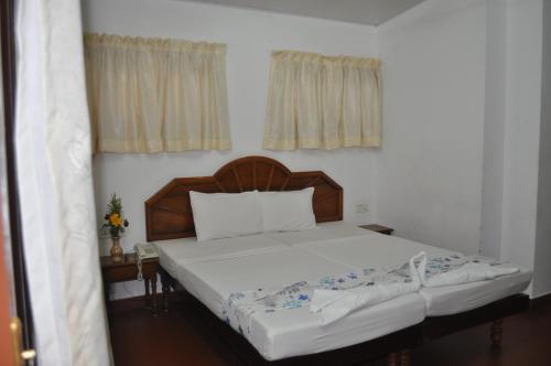a bed with a wooden headboard in a bedroom at Marine Palace Beach Hotel in Kovalam