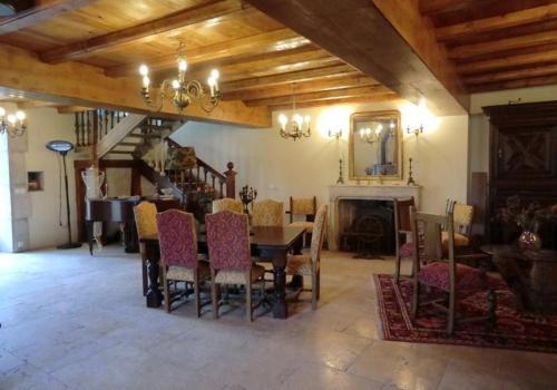 a dining room with a table and chairs and a fireplace at Chateau de Mauras in Chomérac