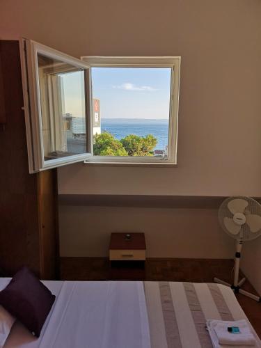 a bedroom with a window with a view of the ocean at Apartment Sea San in Makarska