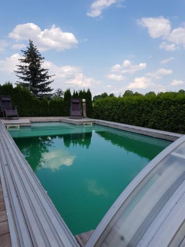 a swimming pool with two chairs in the middle at Ranczo u Nikodema in Silice
