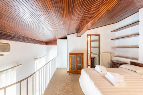 two beds in a room with a wooden ceiling at Cavourotto Terrace by Mmega in Florence