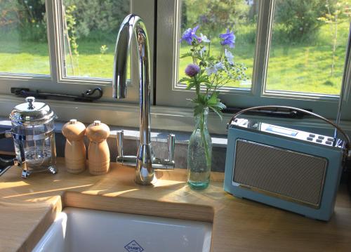 a kitchen counter with a sink and a microwave at The Parlour, for Alton Towers & the Peak District in Uttoxeter