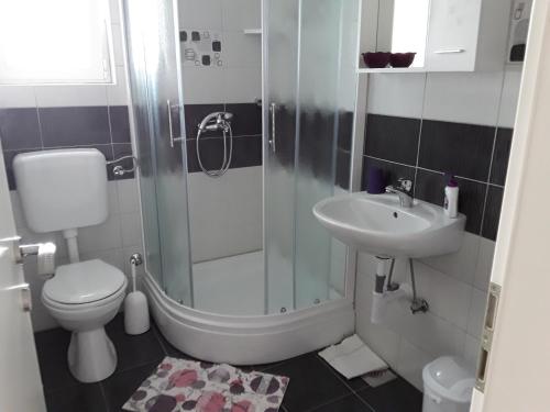 a bathroom with a shower and a toilet and a sink at Apartments Josipa & Niki in Vodice