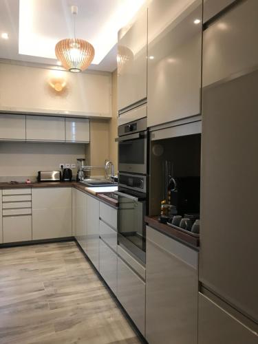 cocina grande con electrodomésticos de acero inoxidable y suelo de madera en NUMA BLANC 300 M PALAIS DES FESTIVALS, en Cannes