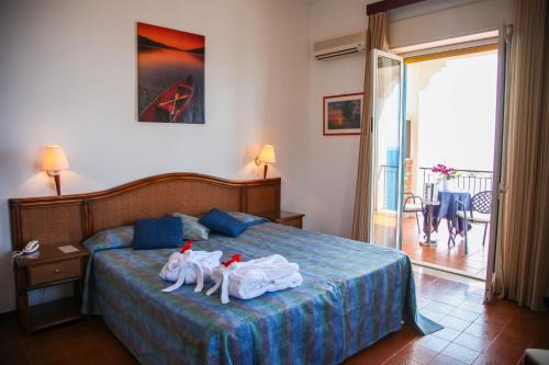 a bedroom with a bed with towel animals on it at Park Hotel Silemi in Letojanni