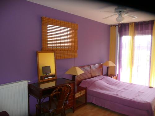 a bedroom with a bed and a desk with a mirror at Villa Le Mauret in Andernos-les-Bains