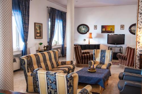 a living room with couches and chairs and a television at Park Hotel Silemi in Letojanni