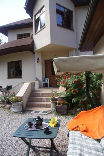 a patio with a table in front of a house at Saulesdarzs in Ragaciems