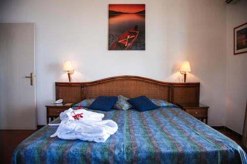 a bedroom with a bed with a robe on it at Park Hotel Silemi in Letojanni